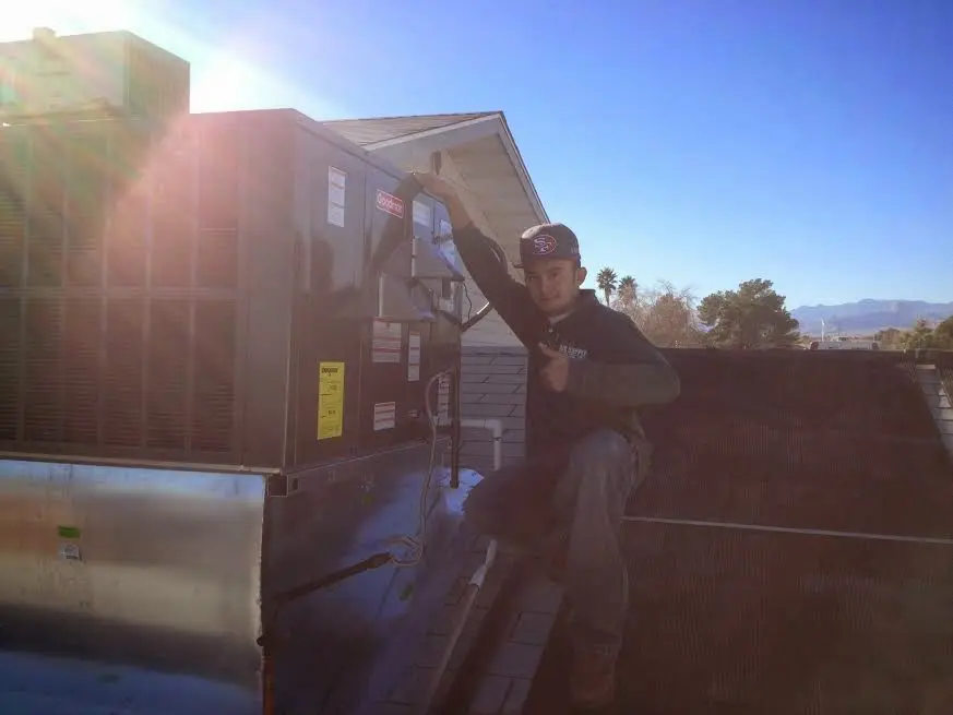 HVAC technician performing HVAC Inspection on a rooftop unit in Orangetown